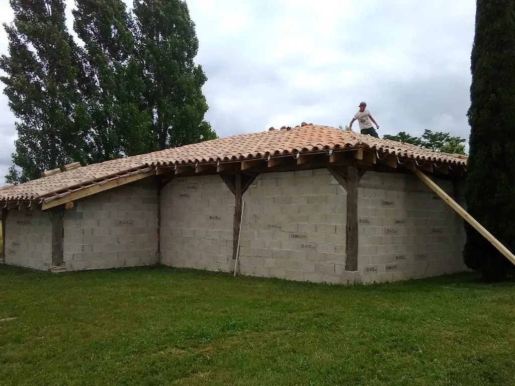 Couvreur posant les tuiles d'une toiture neuve sur charpente bois dans le Tarn
